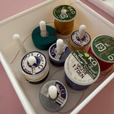 Collection of spools of thread with visible brand labels on a pink background